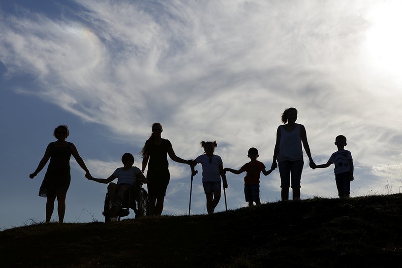 Eine Gruppe Erwachsener und Kinder fasst sich an den Händen.