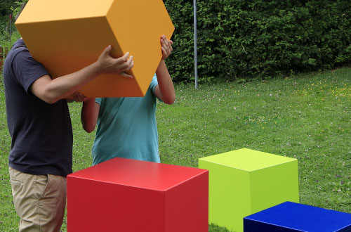 Kinder spielen mit bunten Bausteinen im Garten.